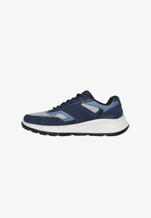 Zapatilla deportiva en azul marino y azul claro, con materiales de malla y gamuza, puntera redonda, entresuela blanca y suela negra. Diseño ajustable con cordones.