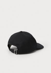 Casquette de baseball en coton noir avec une visière incurvée, une sangle ajustable à l'arrière et un bouton supérieur ; finition texturée subtile.