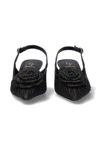 Zapatos de slingback negros con textura tejida y punta afilada. Presentan una roseta decorativa y una correa para el tobillo con herrajes metálicos.
