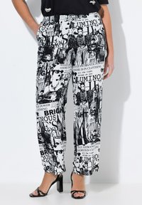 Zwart-witte broek met wijde pijpen, voorzien van een grafische print van tekst en afbeeldingen. Gemaakt van stof met een gladde textuur. Elastische tailleband.