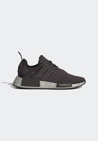 Svarta Adidas NMD-sneakers med texturerad grå sula, mesh-övre, snörning och märkta sid- och häldetaljer mot en enkel ljus bakgrund.
