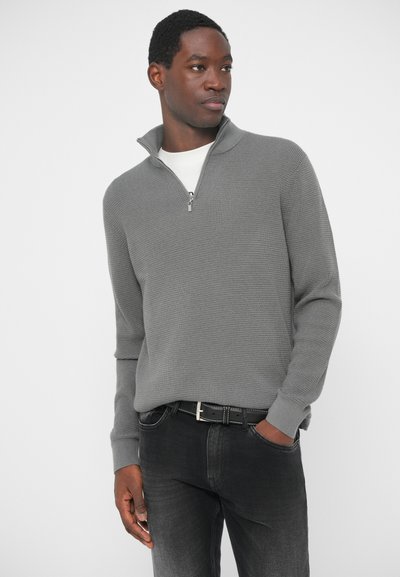 Gray half-zip sweater with a textured knit design. Features ribbed cuffs and hem. Paired with dark jeans and a black belt.