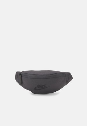 Sort Nike hoftebælte med frontlynlåslomme og justerbar rem, vist på en ensfarvet lys baggrund.