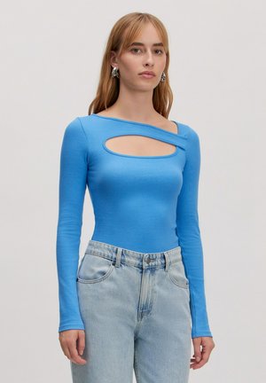 Blauwe lange mouwen bodysuit met een geribbelde textuur en een vooraan uitgesneden ontwerp. Gecombineerd met lichtblauwe high-waisted jeans.