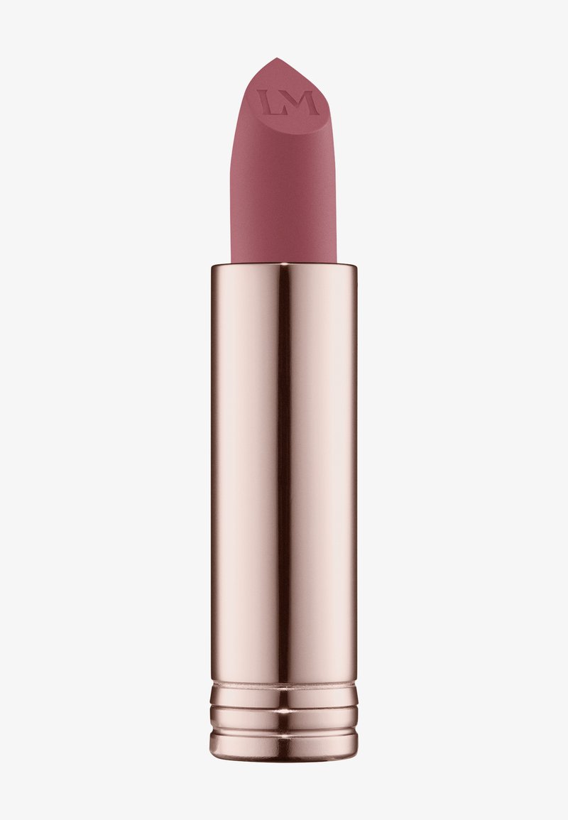 Rossetto opaco in una leggera tonalità mauve con punta affusolata, contenuto in un tubo rosa oro lucido con dettagli texturizzati e una base curva.