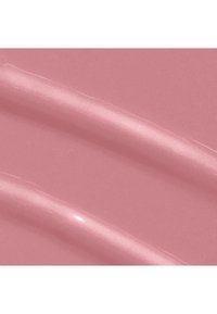 Produit cosmétique lisse et crémeux de couleur mauve clair rosé, appliqué en deux traits diagonaux sur une surface plane.