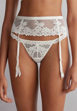 Lace-Gürtel und String-Set in Creme mit floralen Mustern, satinierten Akzenten und verstellbaren Trägern. Weicher, transparenter Stoff überall.