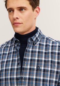 Camicia a quadri nei toni del blu, nero e bianco; colletto button-down; tessuto misto cotone con una texture morbida; presenta un logo sul petto.