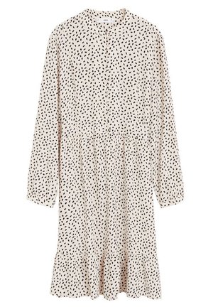 Robe beige à manches longues avec motif de pois noirs irréguliers, col rond, boutonnage devant et ourlet volanté.