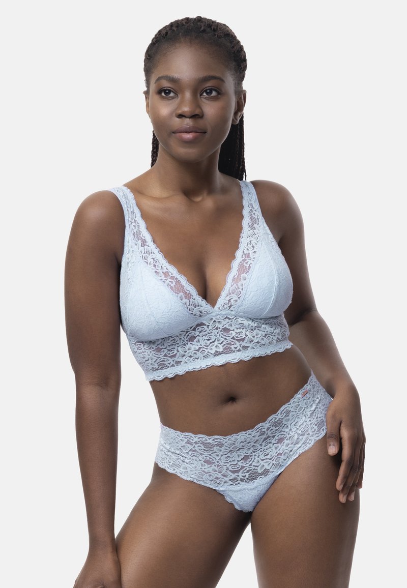 Bralette en dentelle bleu clair avec un décolleté en V profond et des bords festonnés associé à des culottes en dentelle assorties, présentant des motifs floraux intriqués et une texture douce.