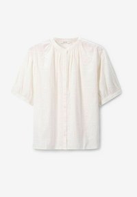 White cotton blouse featuring short puff sleeves, a round neckline, front button closure, and embroidered floral patterns across the fabric.