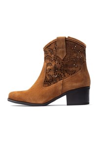 Brown suede ankle boot with perforated floral pattern, low block heel, pointed toe, and short shaft with back tab for easy wear.