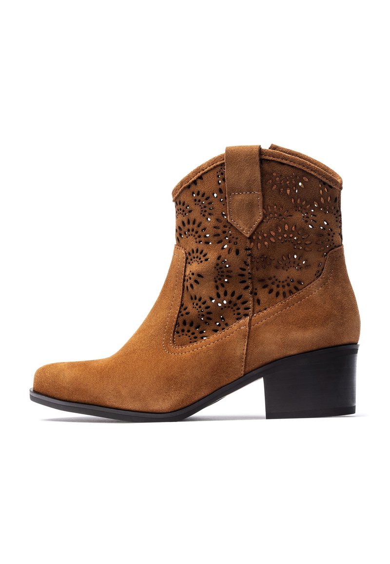 Brown suede ankle boot with perforated floral pattern, low block heel, pointed toe, and short shaft with back tab for easy wear.