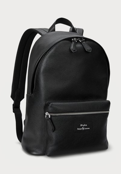 Black leather backpack featuring a rounded shape, textured surface, dual zip closures, and a front zippered pocket with logo label.