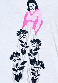 Witte stoffen t-shirt met een grafisch ontwerp van een figuur in roze kleding, met zwarte bloemenmotieven en verticale strepen aan de onderkant.
