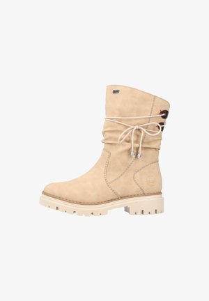 Bottine en daim beige à design lâche, bout rond, semelle en caoutchouc blanc contrastant et détail de lacet décoratif en haut.