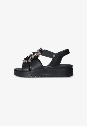 Sandalo platform nero con punta aperta, cinturino elastico e perline decorative nere e grigie sulla parte superiore.