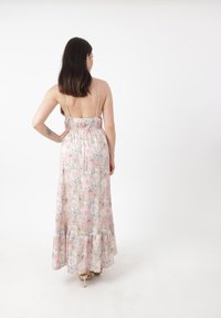 Robe maxi florale avec un corsage ajusté, des bretelles réglables et un ourlet volanté. Présente un fond pastel avec des fleurs roses et bleues.