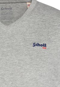 Maglietta in cotone grigia con design a V, con un piccolo logo blu "Schott" e un accento rosso sul petto. Finitura in tessuto testurizzato.