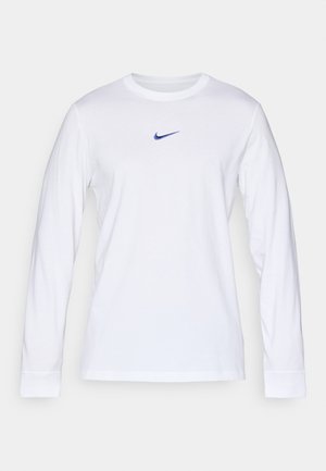 Camiseta blanca de manga larga hecha de algodón con cuello redondo, que presenta un pequeño logotipo azul de Nike centrado en el pecho.