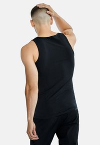 Svart ärmlös tanktopp i ett mjukt tyg. Har en rundad halsringning och en figursydd design, utan synliga mönster eller detaljer.