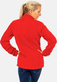 Roter Fleece-Pullover mit hohem Kragen, langen Ärmeln und strukturiertem Finish. Mit lockerer Passform und abgerundetem Saum.