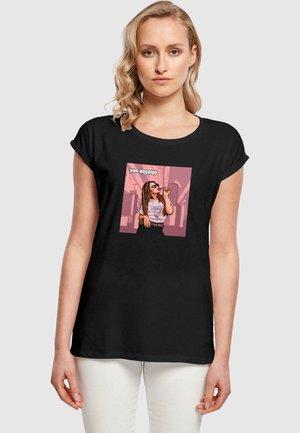 Schwarzes T-Shirt mit kurzen, hochgerollten Ärmeln, das ein farbenfrohes grafisches Design einer Frau zeigt, die ein Getränk hält, mit dem Text "San Antonio" darüber.