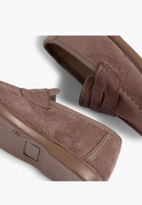 Brązowe zamszowe buty wsuwane o teksturowanym wykończeniu, z kontrastującym materiałowym wykończeniem i gumową podeszwą, z kwadratowym logo na spodzie.