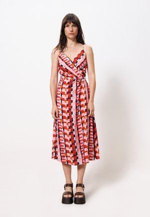 Maxi-jurk in een multicolor geometrisch patroon met rode, roze en blauwe tinten. Lichte stof, wikkelontwerp en spaghettibandjes.