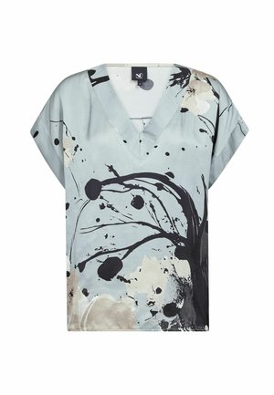 Lyseblå V-halsbluse med korte ærmer, med et abstrakt mønster i sort, beige og hvid bestående af blomster og blækpletter.