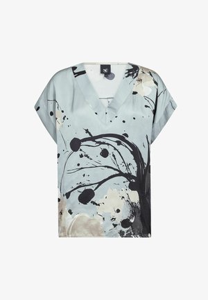Lyseblå V-halsbluse med korte ærmer, med et abstrakt mønster i sort, beige og hvid bestående af blomster og blækpletter.