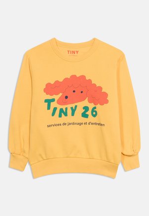 Gelber Sweatshirt mit einer roten Hundeillustration, grünem Text "TINY 26" und schwarzen französischen Worten über Gartendienstleistungen unter der Grafik.