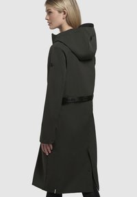 Cappotto impermeabile di un lungo verde scuro con cappuccio, cintura regolabile e polsini con bottoni, caratterizzato da un design elegante e fenditure laterali per il movimento.