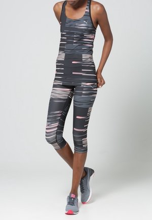 Canottiera atletica nera e leggings capri con motivi a righe orizzontali in grigio, rosa e bianco. Include scarpe grigie con dettagli rosa.