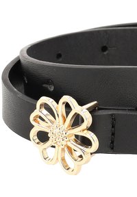 Svart läderbälte med en guldblomma-spänne med utskärningsdesign och en nitar i mitten, vilket ger en kontrast av material och texturer.