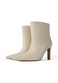 Beez varba saapad, millel on terav varvas, sile tekstuur ja kõrge konts. Lihtne disain, millel on minimaalne kaunistus.