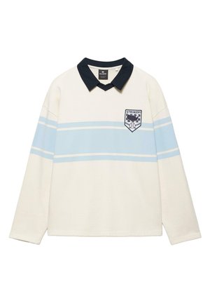 Biela košeľa s dlhým rukávom s jemnými svetlomodrými horizontálnymi pruhmi, čiernym golierom a nášivkou na hrudi s nápisom "STRIKE 91" a grafikou baseballu.