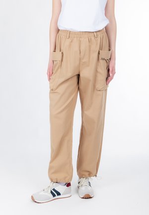 Kaki cargobukser med elastisk talje, to sidelommer, opsmøgede kanter og letvægtsstof. Kombineret med hvide sneakers.