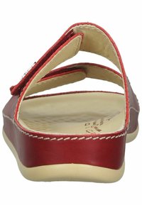 Red leather sandal featuring a split design, with three adjustable straps and a cushioned insole. Smooth texture, contrasting stitching detail.