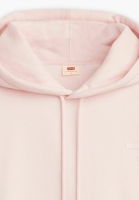 Sudadera rosa claro con capucha con cordón y textura suave, que presenta un pequeño logotipo blanco de Levi's cosido en el frente.