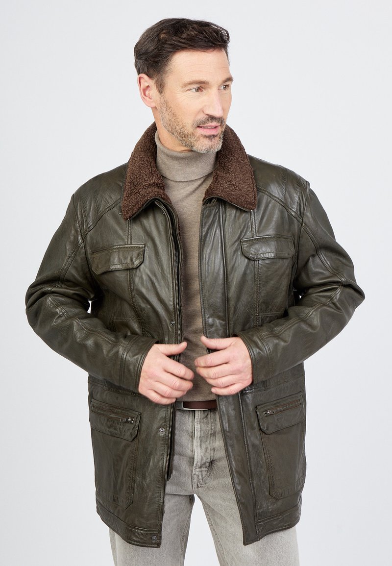 Lederjacke in dunkelolivgrün mit einem braunen Schaffellkragen, ausgestattet mit vier Fronttaschen und einem Reißverschluss. Glatte Textur, lässige Passform.