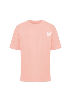 T-shirt color pesca in cotone, con un piccolo design di farfalla bianca sulla parte sinistra del petto. Maniche corte e scollatura rotonda.