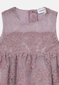 Ärmlös klänning i ljus mauve, med ett strukturerat spetsöverdrag och blommig broderi samt en veckad kjol. Bakre stängning med tygöggla.