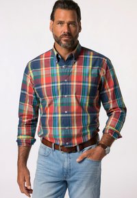 Camisa de cuadros abotonada en tonos rojo, verde y azul; cuenta con cuello, mangas largas y una silueta ajustada. Lleva un cinturón marrón.