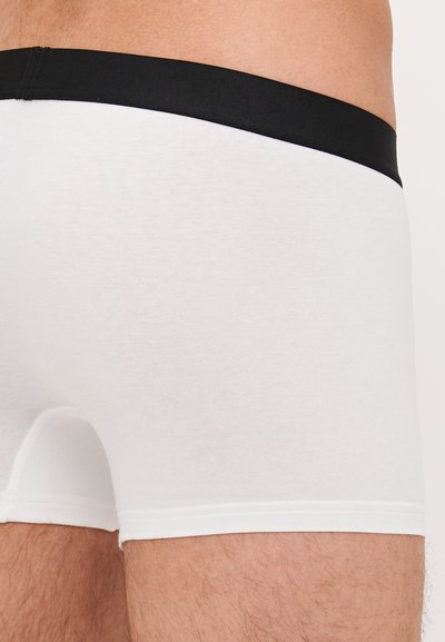 Boxeri din bumbac alb, cu un brâu elastic negru, având o textură netedă și cusături curate. Fără modele vizibile sau elemente metalice.