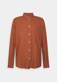 Chemise à manches longues, boutonnée, en coton brun riche, avec un col classique, une poche avant et des boutons blancs contrastant sur la patte de boutonnage.