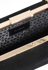 Zwarte suède handtas met een gouden metalen frame. De gevoerde binnenkant heeft een patroonontwerp. Inclusief een label in het binnenvak.