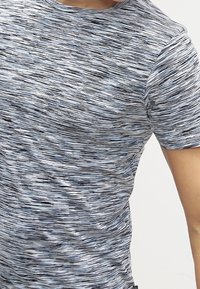 Šedé a modré tričko s krátkým rukávem s texturovaným, pruhovaným vzorem. Kulatý výstřih, měkká tkanina a přiléhavý střih.