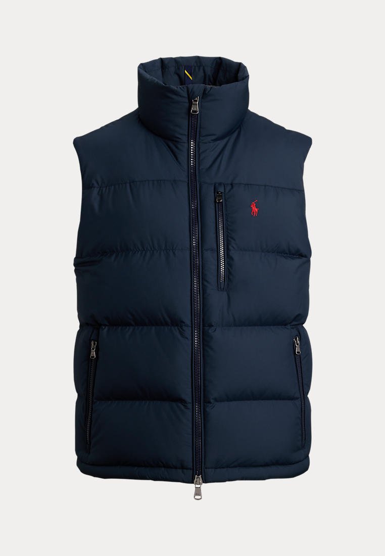 Veste sans manches matelassée bleu marine avec col montant, fermeture éclair devant, poche poitrine zippée et petit logo rouge sur le côté gauche de la poitrine.