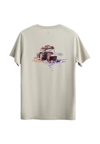 Beige katoenen T-shirt met een kleurrafiek van een filmcamera op de achterkant, gedetailleerd met rode, paarse en witte accenten.